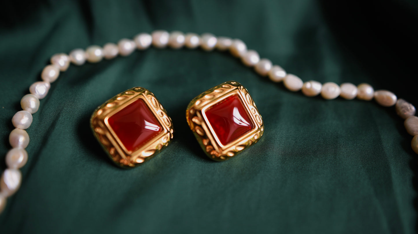 Gold earrings with a red stone