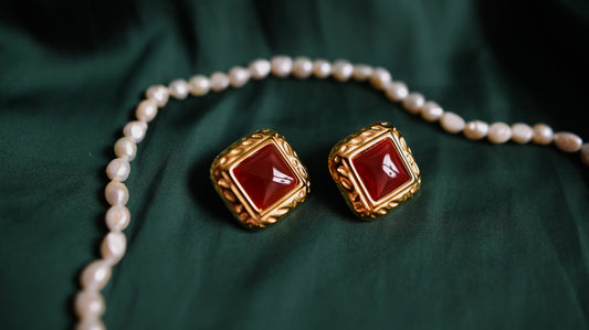 Gold earrings with a red stone