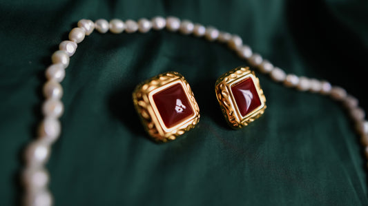 Gold earrings with a red stone