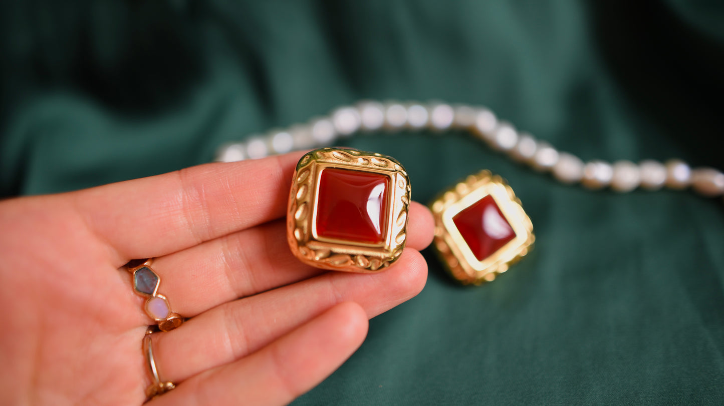 Goldene Ohrringe mit rotem Stein