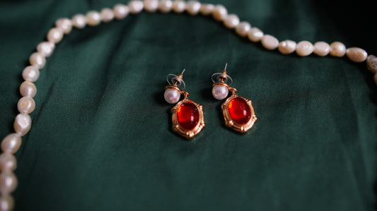 Gold earrings with red accent and pearl