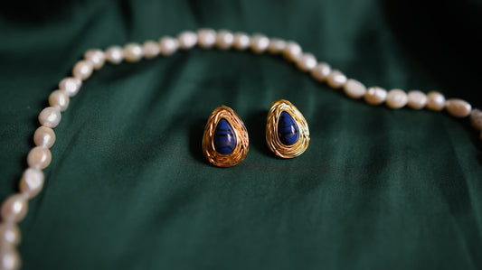 Gold earrings with a deep blue stone 
