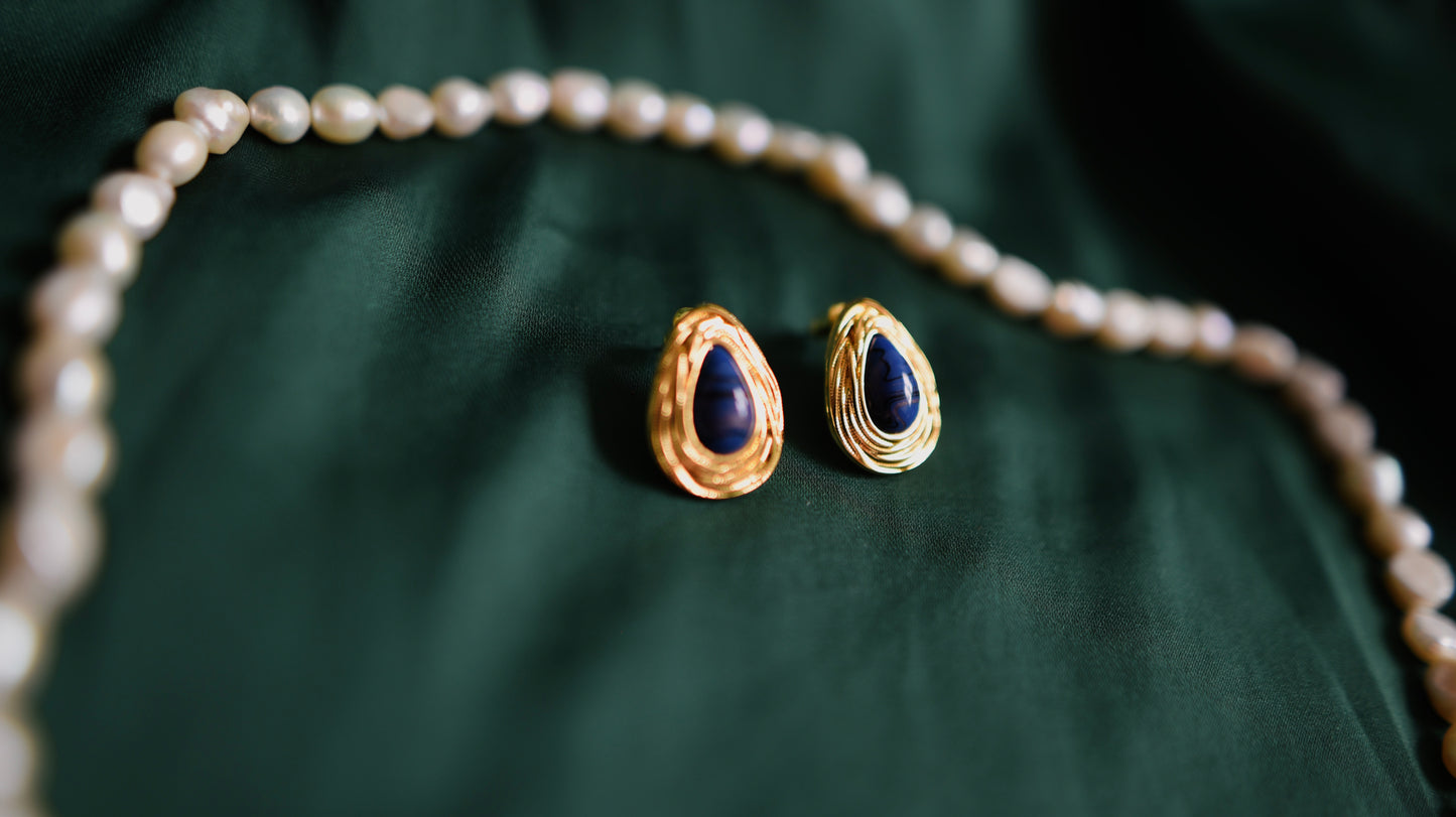 Goldene Ohrringe mit tiefblauem Stein